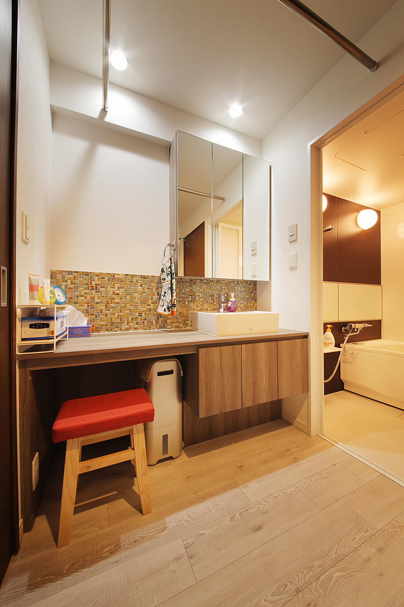 洗面台は木とタイルを組み合わせてナチュラルな雰囲気に。広く取ったユーティリティーは室内干しをするにも便利。