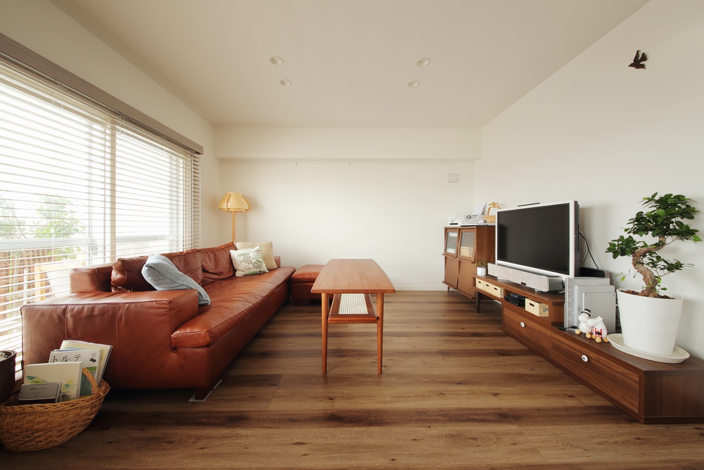 リビングは家具を低くしてすっきりと広く見せている。ツートンの色ムラのある木フローリングがいい味を出している。