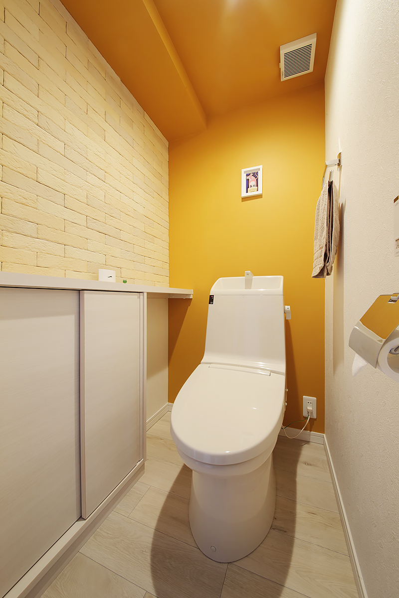 トイレの壁と天井は鮮やかなイエローにしてポップに。調湿・吸着機能に優れたエコカラットを採用。