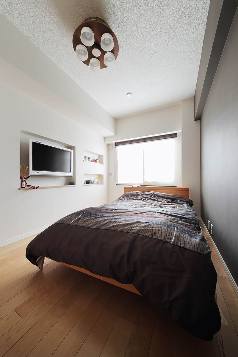 寝室はコンパクトながら壁厚を利用した壁掛けTVや飾り棚、アクセントカラークロスなど、すっきりとした印象。