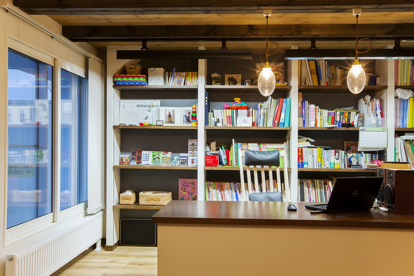 リビングを見渡すことができる書斎はご主人の仕事場。造作の書庫にすっぽり収納されている。