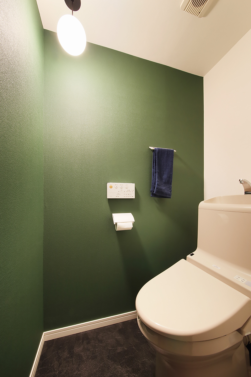 落ち着いたトーンのグリーンとあかりでトイレ空間を演出。