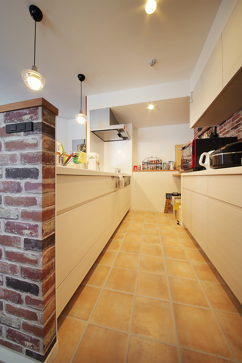 収納もたっぷりで使いやすいキッチン。床はアンティーク仕上げのテラコッタ調フロアに。