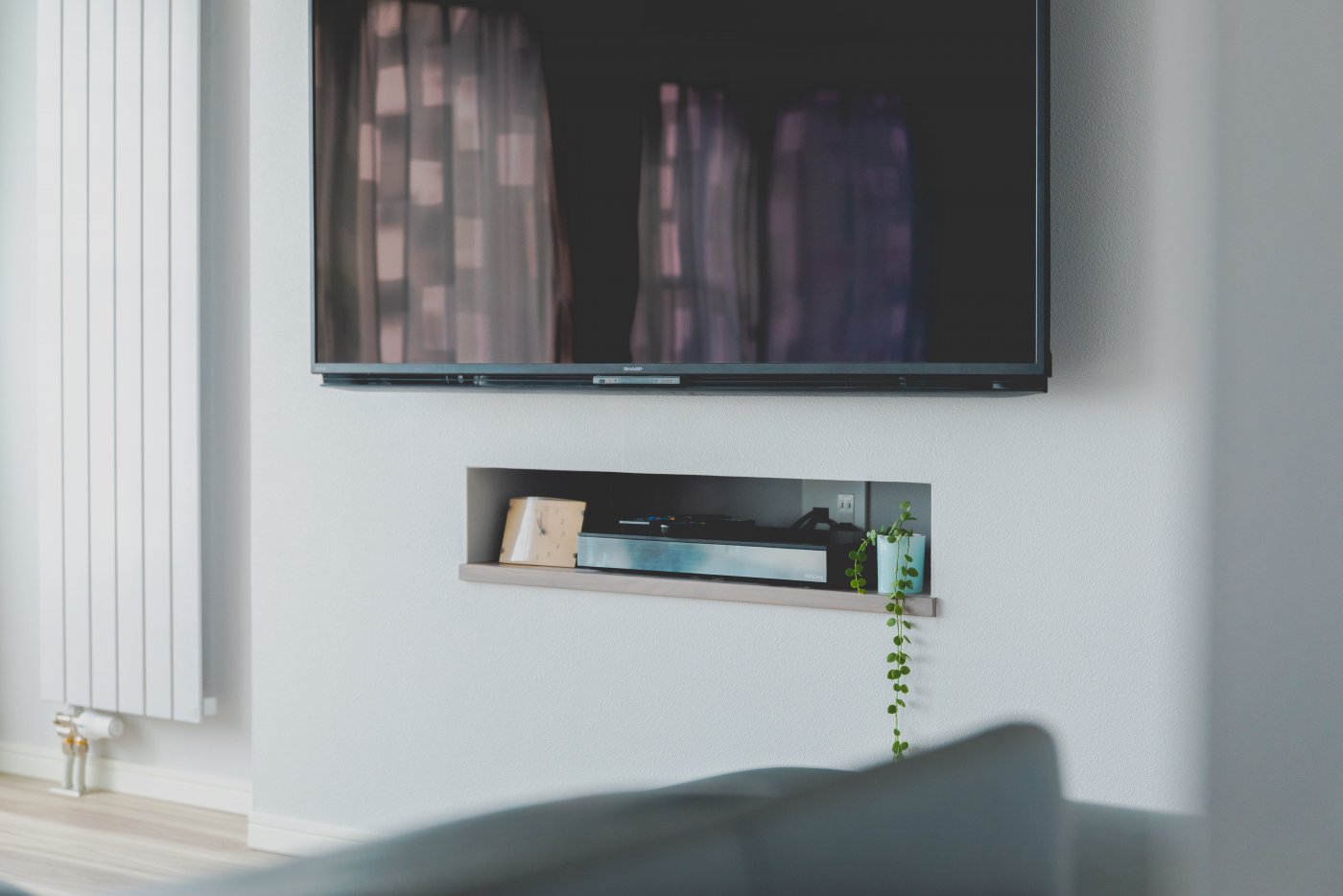 テレビは壁掛けにし、収納を埋め込みに。家具を減らしてすっきりと暮らす。