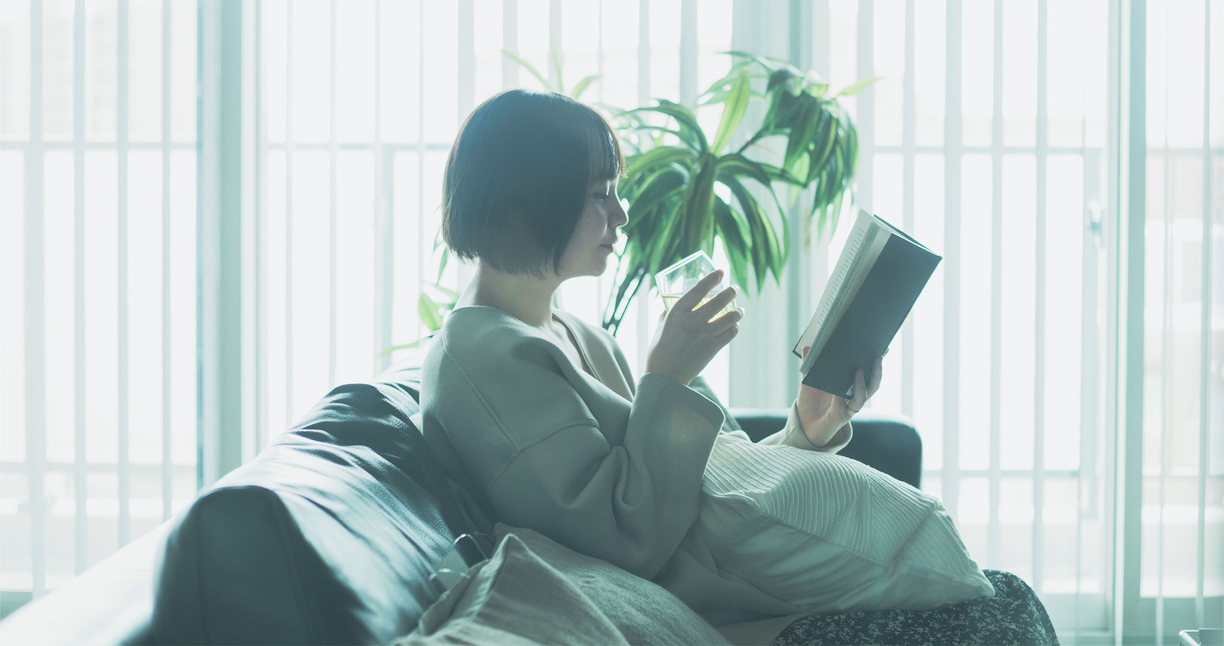 部屋で本を読んでいる女性