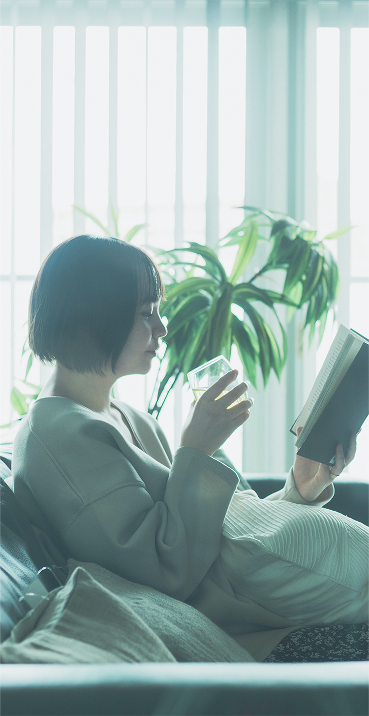 部屋で本を読んでいる女性